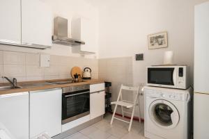 a kitchen with a washing machine and a microwave at Downtown flat historic Reggio in Reggio di Calabria +10 photos