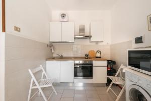 a kitchen with white cabinets and white appliances at Downtown flat historic Reggio in Reggio di Calabria