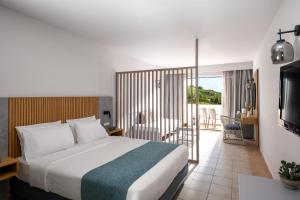 a hotel room with a bed and a balcony at Mare Village in Ierapetra