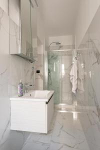 a white bathroom with a sink and a shower at Downtown flat historic Reggio in Reggio di Calabria