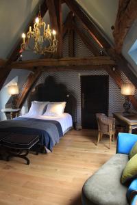 a bedroom with a large bed and a chandelier at L'Hibernie in Rochefort-en-Yvelines