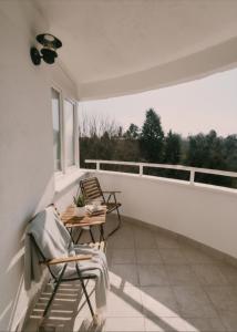 a balcony with two chairs and a table and a window at Apartment Rea in Čapljina