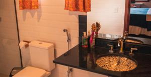 a bathroom with a toilet and a sink at Pousada Canto do Papagaio in Aiuruoca