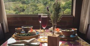 a table with glasses of wine on a table with a window at Pousada Canto do Papagaio in Aiuruoca