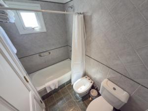 a small bathroom with a toilet and a bath tub at GRAN PALAZZO Hotel in Villa Gesell +12 photos