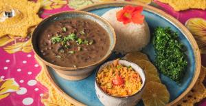 a plate of food with a bowl of soup and rice at Pousada Canto do Papagaio in Aiuruoca +48 photos