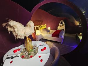 a room with a bed and a table with a vase at La Bulle Des Anges in Illoud +12 photos
