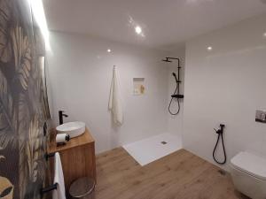 a white bathroom with a sink and a toilet at Apartamentos Porta do Espolón in Noya