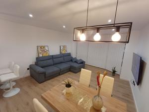 a living room with a blue couch and a table at Apartamentos Porta do Espolón in Noya