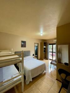 a bedroom with two bunk beds and a living room at Hotel Barichello in São Miguel das Missões
