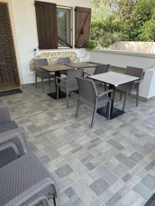 a patio with tables and chairs on a patio at B&B Angolo Magico in Baia Di Gallipoli
