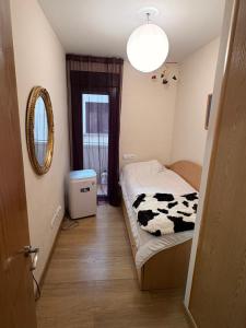 a small room with a bed with a cow blanket at Ático Centro in Socuéllamos