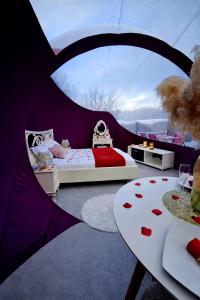 a bedroom with a tent with a bed and a table at La Bulle Des Anges in Illoud