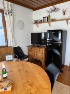 a kitchen with a wooden table and a black refrigerator at 4 Elements Appartmenthaus Monarda in Flachau