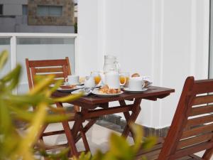 a wooden table with breakfast food on it at GRAN PALAZZO Hotel in Villa Gesell