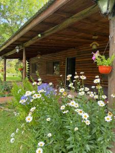a garden with flowers in front of a cabin at Campo Los Teritos in Abasto