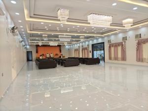 a large banquet hall with a white floor and chandeliers at The KP RESORT in Chīrgaon