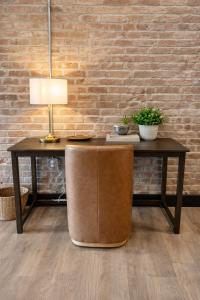 a table with a lamp on top of it next to a brick wall at Brick & Bed Riverfront Lofts, T 401 in Saint Louis +3 photos