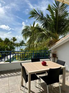 a table and chairs on a balcony with a view of the ocean at Blue Marine Apartment in Baie Nettle