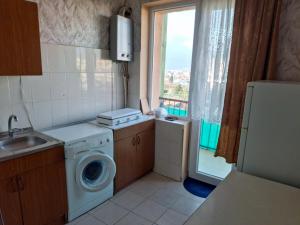 a small kitchen with a washing machine and a window at APARTAMENTS Verkvebi in Gori