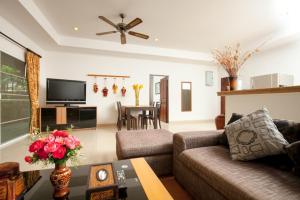 a living room with a couch and a table at Romanee Villa by G Estate in Rawai Beach