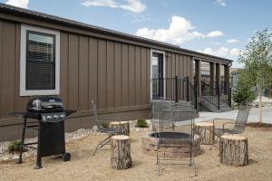 a patio with chairs and a grill and a house at Sun Outdoors Rocky Mountains in Granby