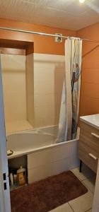 a bathroom with a bath tub with a shower curtain at KAZ Les pêchers in Saint-Denis