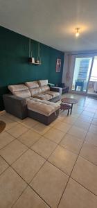 a living room with a couch and a table at KAZ Les pêchers in Saint-Denis