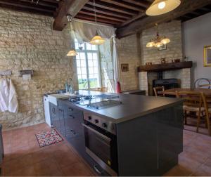 a kitchen with a stove top oven in a room at La Gironie in Pomport