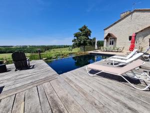 a deck with two chairs and a swimming pool at La Gironie in Pomport