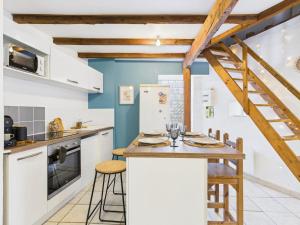 a kitchen with white cabinets and a table with chairs at Le Petit Cocon de Ambre in Saint-Paul