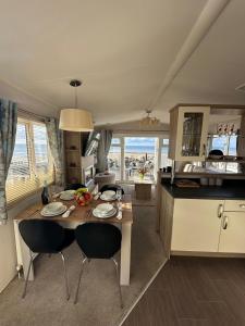 a kitchen and living room with a table and chairs at Dolphin View in Llanddwywe