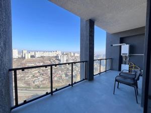 a balcony with a chair and a view of a city at Designer View Vake in Itʼkhvisi +6 photos