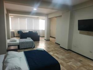 a room with two beds and a flat screen tv at OCEANIk SUITES & HOTEL in Guayaquil