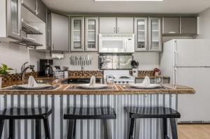 a kitchen with a counter with stools and a refrigerator at Base Camp for all of Sandpoint and Lake Pend Oreille Adventures in Sandpoint