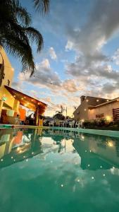 a swimming pool with some chairs and a building at Hotel Zona Sul in São Gabriel