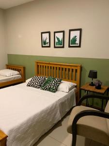 a bedroom with two beds and a table with a lamp at Hotel Zona Sul in São Gabriel +29 photos