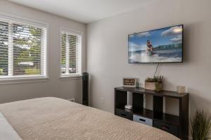 a bedroom with a bed and a tv on the wall at Base Camp for all of Sandpoint and Lake Pend Oreille Adventures in Sandpoint