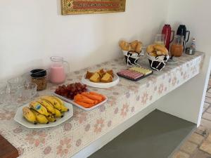 a table with plates of fruit and vegetables on it at Oca Teko Porã in Genipabu