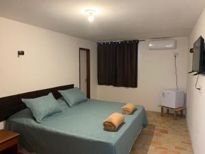 a bedroom with a bed with two towels on it at Oca Teko Porã in Genipabu