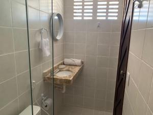 a bathroom with a shower with a sink and a toilet at Oca Teko Porã in Genipabu +22 photos