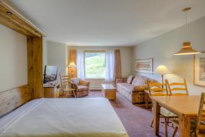 a living room with a large bed and a table at Cahilty #122 home in Sun Peaks