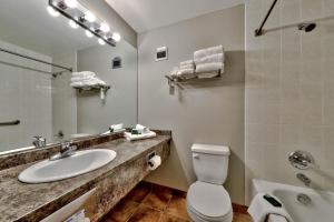 a bathroom with a sink and a toilet and a mirror at Cahilty #122 home in Sun Peaks