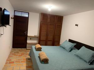 a bedroom with a bed with towels on it at Oca Teko Porã in Genipabu
