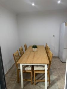 a wooden table with chairs and a potted plant on it at Elegant Getaway - Spacious 3 Bedroom Apartment -Lisbon Baixa da Banheira in Lavradio