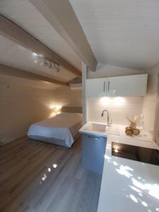 a kitchen with a sink and a bed in a room at Chalet cosy avec terrasse & hamac, calme, proche plage, parking, NC Properties in Grimaud +7 photos