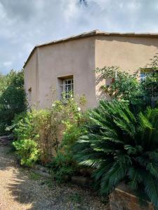 a building with a window on the side of it at Chalet cosy avec terrasse & hamac, calme, proche plage, parking, NC Properties in Grimaud