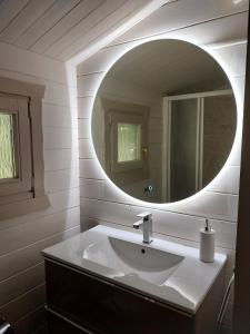 a bathroom with a sink and a round mirror at Chalet cosy avec terrasse & hamac, calme, proche plage, parking, NC Properties in Grimaud