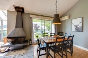 a dining room with a table and a fireplace at L'Érablière 75 - 3 chambres - 7 personnes in Saint-Férréol-les-Neiges