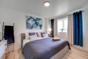 a bedroom with a large bed with blue curtains at L'Érablière 75 - 3 chambres - 7 personnes in Saint-Férréol-les-Neiges +12 photos